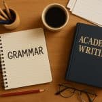 Open grammar book, pen, and academic papers emphasizing proper grammar in academic writing