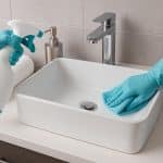 Modern bathroom with sparkling clean tiles and innovative cleaning products on countertop