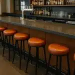 Modern restaurant interior highlighting stylish bar stools lined up along a sleek counter