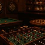 Various popular bar games including darts, pool, and foosball in a lively pub setting