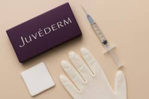 Juvederm filler syringe and cosmetic consultation tools on clinic table before treatment session